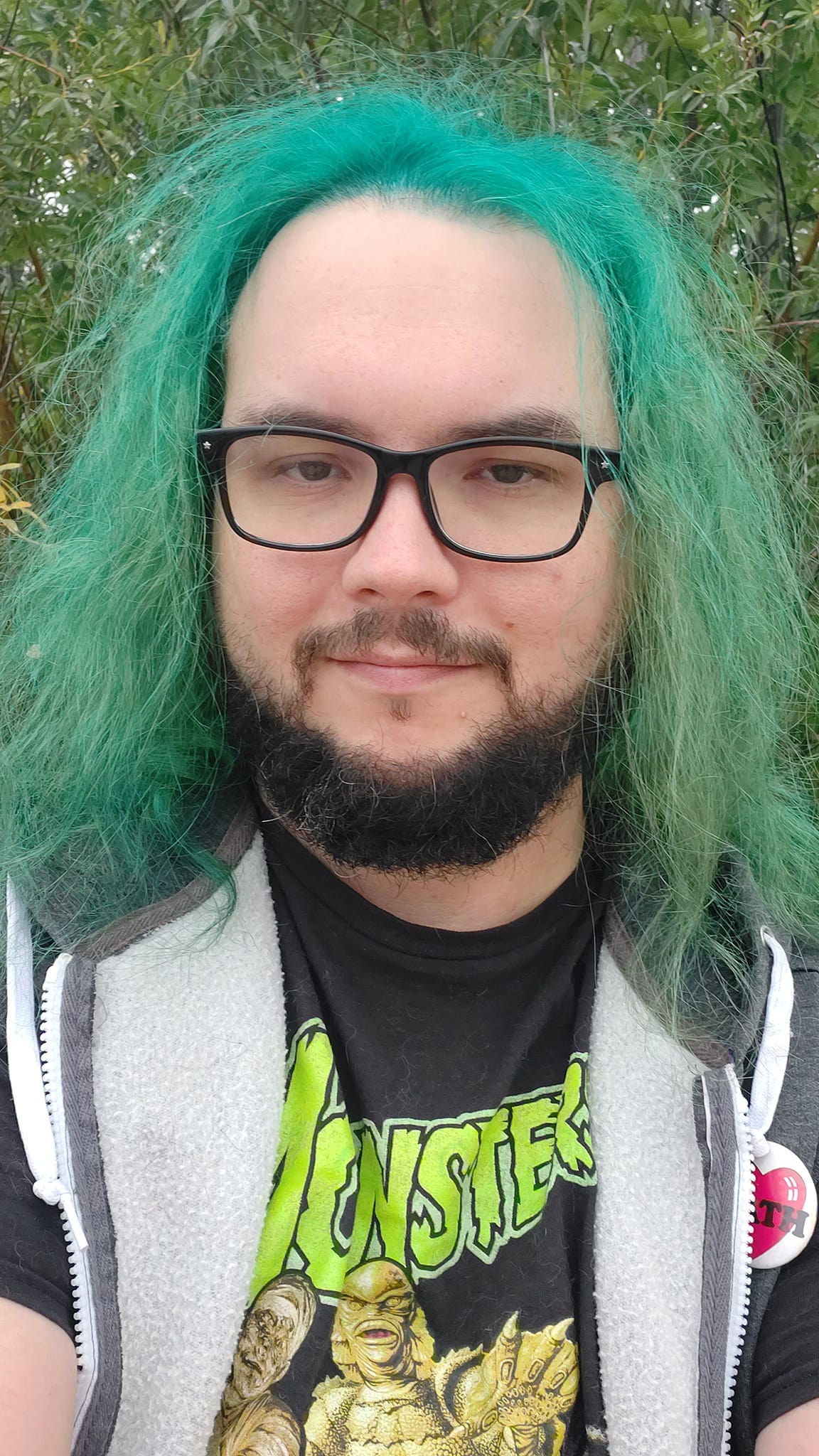 A man with green hair stands outside at a boulder breakwater, photo 4